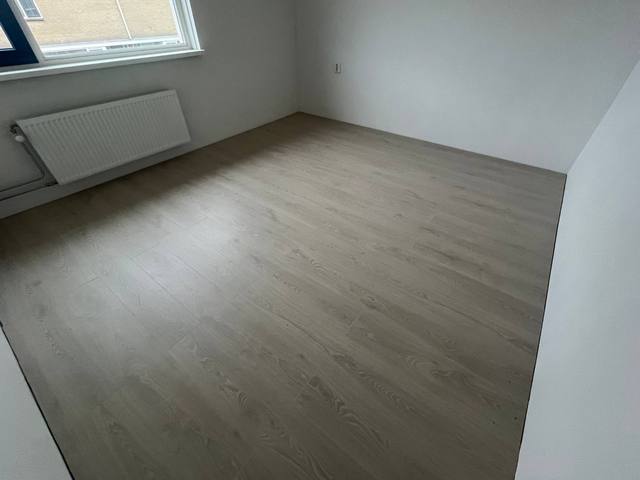 Kamer met nieuw gelegde laminaatvloer, opgeleverd