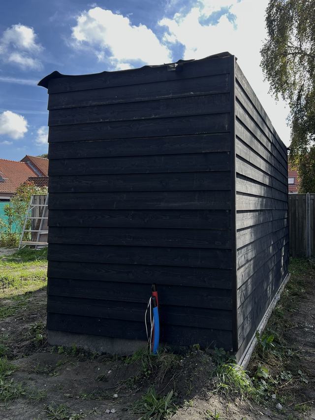 Afgewerkte tuinschuur met zwarte rabatdelen